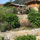 Natursteinmauern und heimische Pflanzen passen perfekt in die alpine Umgebung