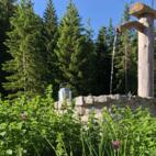 Uriger Brunnen im alpinen Garten des Chaletdorfes LaPosch