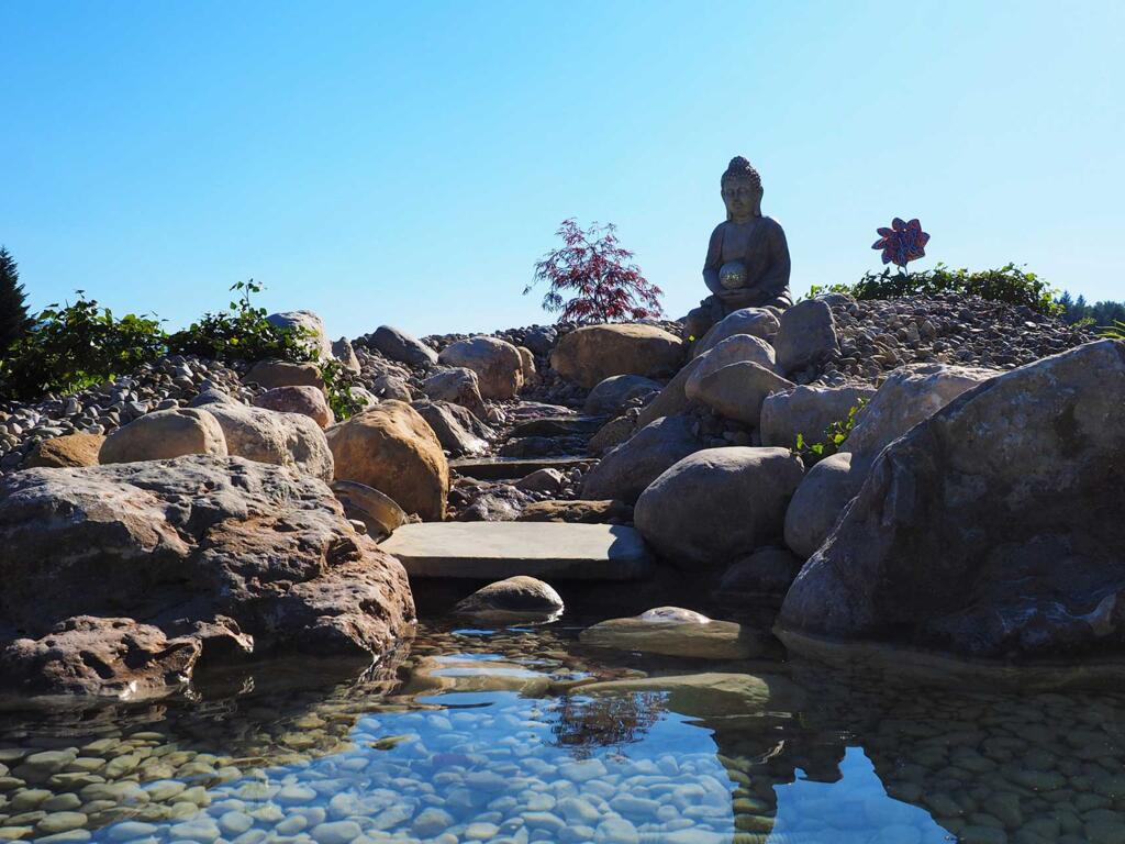 Bachlauf mit japanischer Steinfigur für individuelle Gartengestaltung