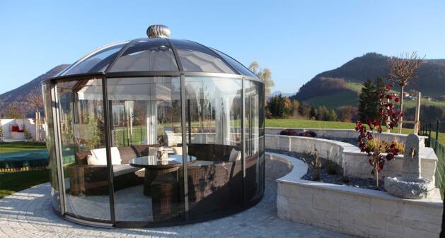 Natursteinmauer gibt dem Garten Struktur und dem Pavillon Schutz abgestimmt zur Pflasterung