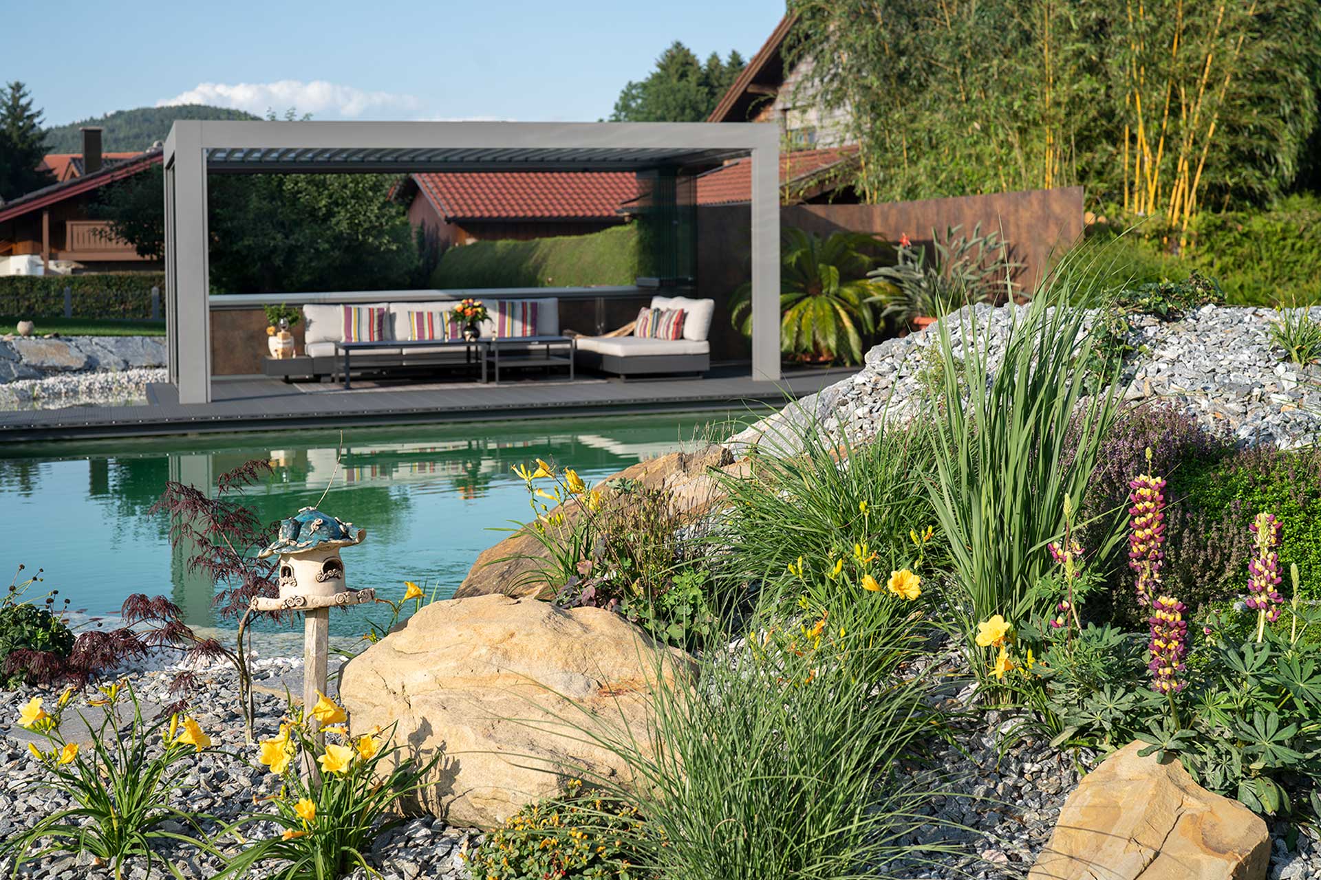 Holz und Naturstein im Naturpool mit energieeffizienter Technik